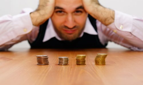 An unhappy and concerned man looking at the coins